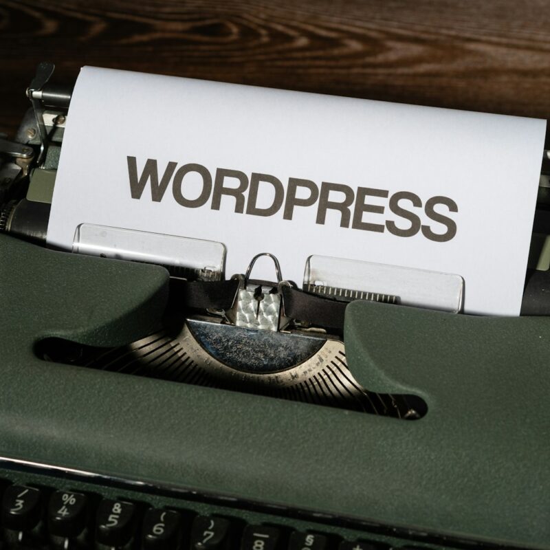 a close up of a typewriter with the word wordpress printed on it